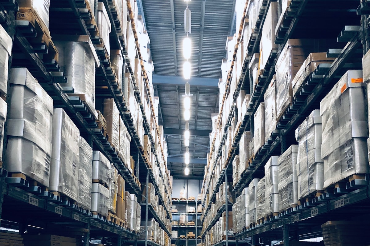 High-bay warehouse aisle with racking — where the supply chain does its work
